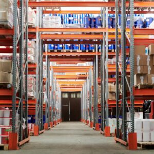 Wide angle view of a warehouse with stocked shelves and boxes.